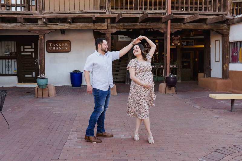 Pregnant mother dances with husband in Old Town Albuquerque