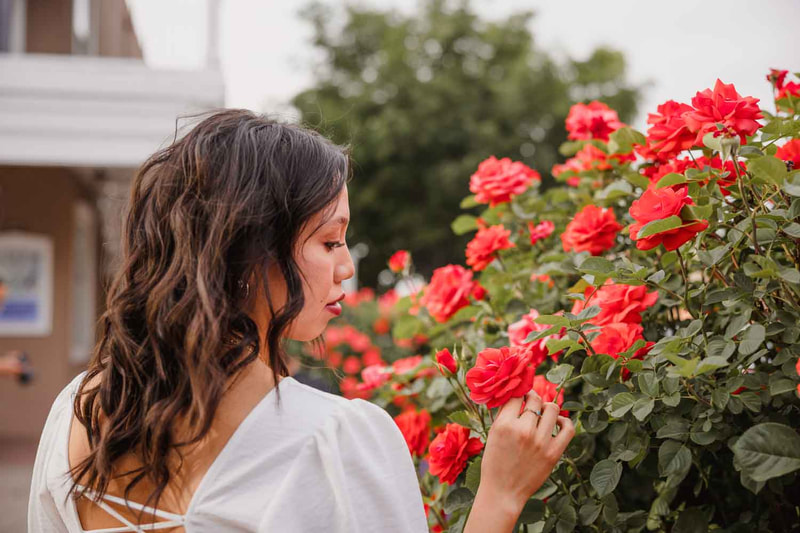Female senior looks at red roses.